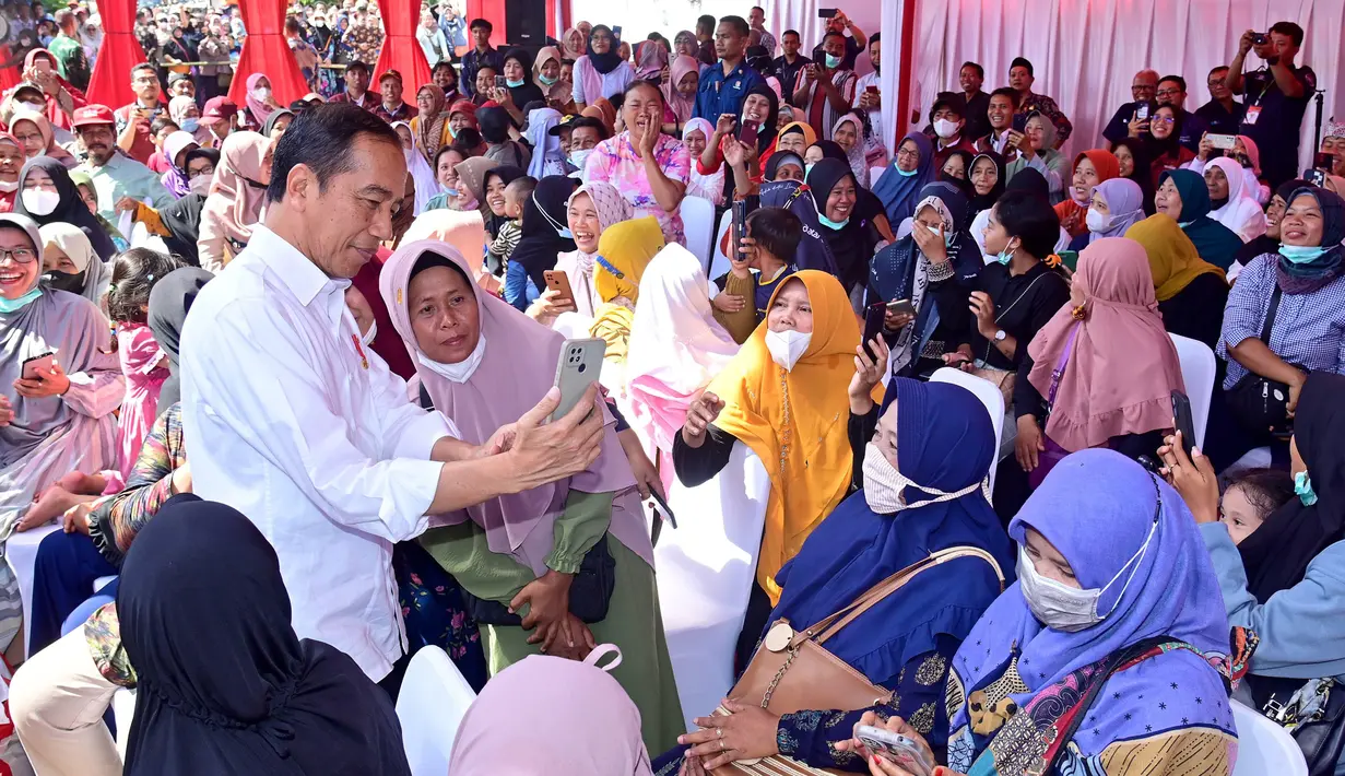 Presiden Joko Widodo atau Jokowi foto bersama warga saat menyerahkan Bantuan Langsung Tunai (BLT) El Nino kepada sejumlah penerima manfaat di Kantor Pos Genteng, Kabupaten Banyuwangi, Provinsi Jawa Timur, Rabu (27/12/2023). (Biro Setpres Kepresidenan)