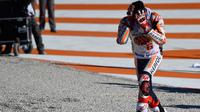 Pembalap Spanyol Repsol Honda, Marc Marquez meluapkan kegembiraannya sambil memegang kepala setelah memenangkan balapan seri ke 18 MotoGP Grand Prix Valencia di Sirkuit Ricardo Tormo, Valencia (12/11). (AFP PHOTO / Jose Jordan)
