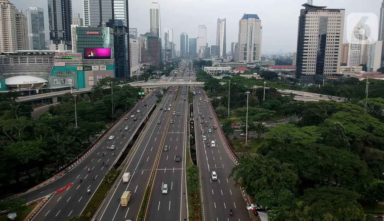 Foto aerial kendaraan melintas di Jalan Jenderal Sudirman, Jakarta, Selasa (24/3/2020). Sejumlah ruas jalan utama ibu kota lebih lengang dibandingkan hari biasa karena sebagian perusahaan telah menerapkan bekerja dari rumah guna menekan penyebaran COVID-19. (Liputan6.com/Faizal Fanani)