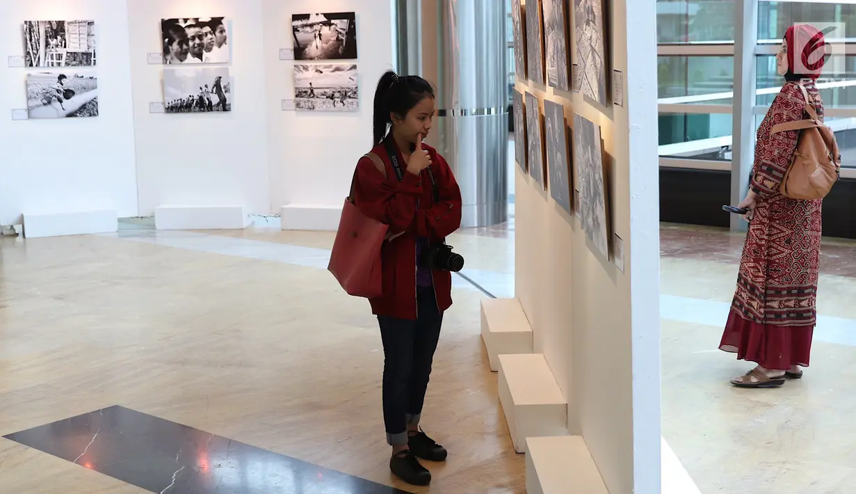 Pengunjung melihat karya fotografi yang dipajang dalam pameran fotografi bertajuk “Semangat Anak Indonesia dalam Bingkai Hitam Putih” di TIM, Jakarta, Selasa (20/3). Enam foto di antaranya merupakan foto pemenang. (Liputan6.com/Immanuel Antonius)