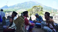 Warga berdoa di makam Desa Selo, Kabupaten Boyolali, Kamis (3/5). Tradisi ini Sebagai perayaan menyambut datangnya bulan ramadan, kemudian dilanjutkan makan bersama di pertigaan jalan desa. (Liputan6.com/Gholib)