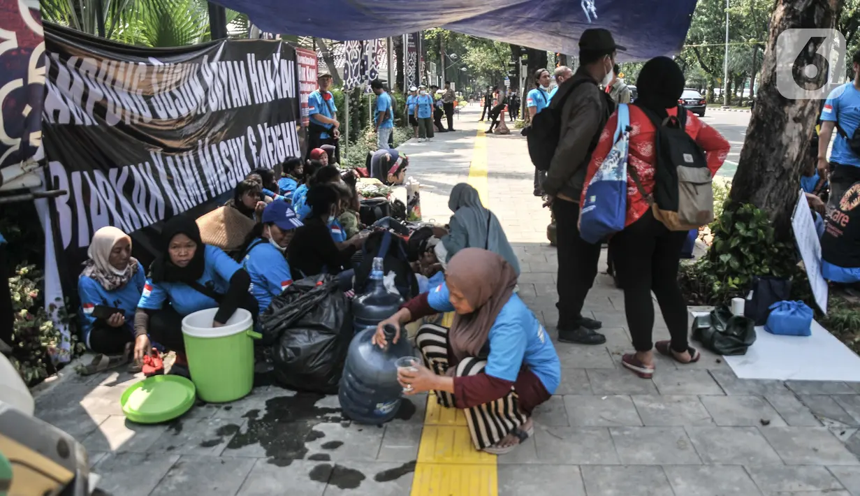 Warga gusuran Kampung Bayam saat menggelar aksi di depan Balai Kota DKI Jakarta, Kamis (1/12/2022). Dengan membawa terpal dan perabotan rumah tangga, puluhan korban gusuran Kampung Bayam mendatangi Balai Kota untuk menuntut PT Jakarta Propertindo (JakPro) segera menyerahkan kunci hunian Kampung Susun Bayam (KSB) serta memberikan harga sewa yang murah. (merdeka.com/Iqbal S Nugroho)