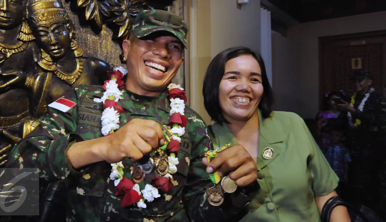 Letnan Dua Inf Poltak Siahaan berbagi kebahagiaan bersama pasangannya sambil menunjukkan medali yang diraihnya di ajang Australian Army Skill and Arms Meeting (AASAM) 2016, Banten, Senin (23/5/2016). (Liputan6.com/Helmi Fithriansyah)