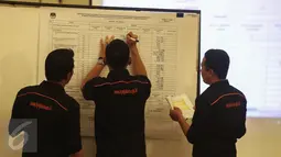 Petugas menulis data saat rekapitulasi penghitungan sura tingkat provinsi Pilkada DKI Jakarta di Grand Sahid, Jakarta, Minggu (26/2). Rekapitulasi ini rangkaian tak terpisahkan dari pencoblosan dan penghitungan suara di TPS. (Liputan.com/Faizal Fanani)