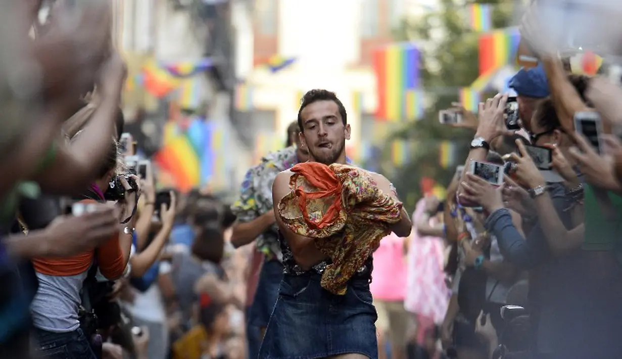 Ekspresi seorang peserta saat lomba lari dengan high heels dalam perayaan Gay Pride di Madrid, Spanyol, (3/7/14). (AFP PHOTO/Gerard Julien)