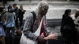 Penggemar film horor memakai kostum dan berdandan menyerupai zombie saat berpartisipasi dalam acara Zombie Walk di Place de la Republique, Paris, Sabtu (12/10/2019). Sejak 2008, acara Zombie Walk digelar untuk orang-orang yang terobsesi dengan mayat hidup. (Martin BUREAU / AFP)