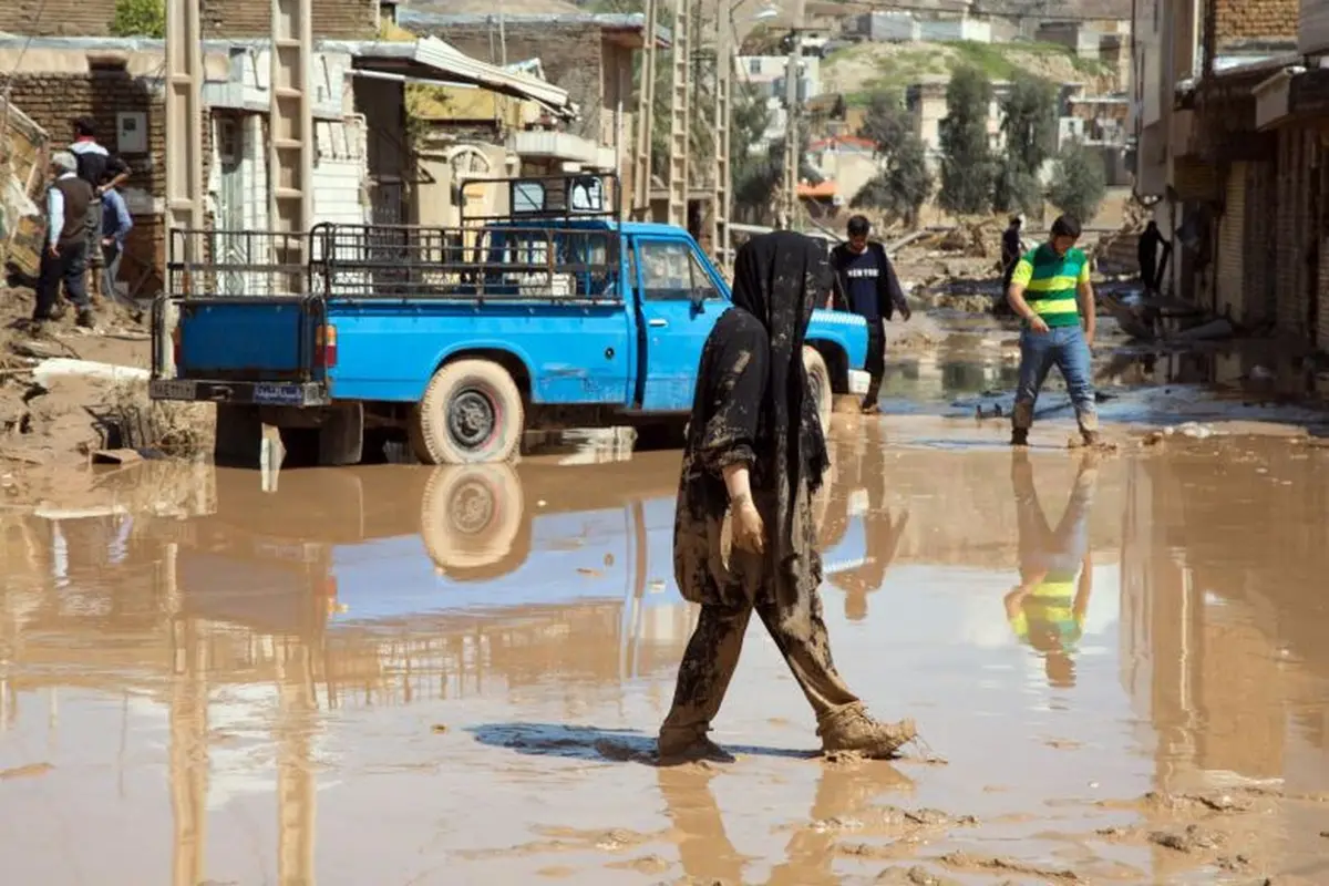 Wanita berjalan di lokasi bekas banjir Iran yang sudah surut di Poldokhtar, Provinsi Lorestan. (AFP)