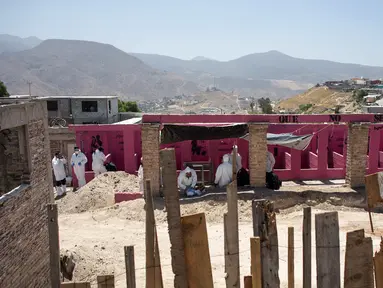 Tim forensik memeriksa sebuah kuburan massal yang ditemukan di Tijuana timur, Meksiko (17/8). Menurut pejabat setempat, lebih dari 600 fragmen tulang manusia ditemukan di perbatasan Meksiko-AS. (AFP Photo/Guillermo Arias)