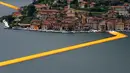 Instalasi seni 'The Floating Piers' buatan seniman  Christo Vladimirov Yavachev atau dikenal sebagai Christo , di Danau Iseo , Italia utara , (16/6).Pria 80 tahun ini  merancang karya seni besarnya untuk menarik wisatawan.  (REUTERS / Stefano Rellandini)
