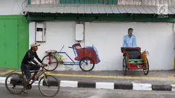 Pengendara sepeda melintas di depan Kampung Tematik Sketsa di kawasan Penjaringan, Jakarta Utara, Rabu (1/7). Sketsa-sketsa yang menghiasi kawasan tersebut dibuat dalam rangka menyambut Asian Games XVIII Tahun 2018. (Liputan6.com/Immanuel Antonius)