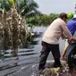 Personel Polres Pelalawan membantu dorong sepeda motor warga yang mogok karena nekat melintasi banjir di Jalan Lintas Timur Sumatra. (Liputan6.com/M Syukur)