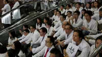 Ratusan dokter mendengarkan orasi saat aksi protes di dalam sebuah rumah sakit di Hong Kong, Rabu (21/10). Ratusan dokter umum tersebut menuntut kenaikan gaji sejalan dengan kenaikan upah pegawai negeri di kota itu. (REUTERS/Bobby Yip)