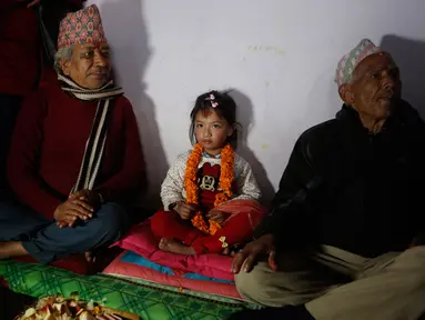 Gadis berusia lima tahun yang bernama Nihira Bajracharya (tengah) diapit oleh pendeta Hindu setelah dia ditunjuk sebagai Dewi Hidup baru yang dikenal Kumari di sebuah kuil Hindu di Patan, Lalitpur, Nepal (5/2). (AP Photo / Niranjan Shrestha)