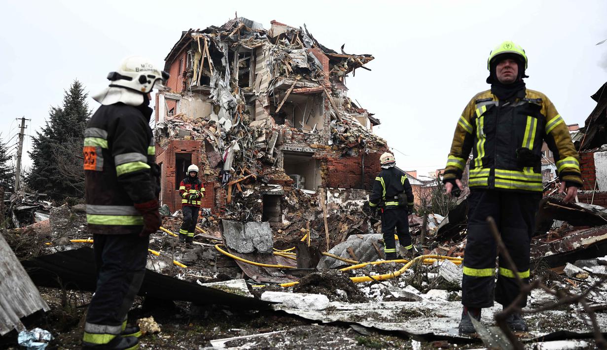 Serangan tersebut terjadi jelang peringatan peringatan empat tahun invasi militer Rusia ke Ukraina. Tampak dalam foto, tim penyelamat Ukraina bekerja di lokasi rumah yang rusak parah akibat serangan udara di Sofiivska Borshchagivka, wilayah Kyiv pada Minggu 22 Februari 2026. (Henry NICHOLLS/AFP)