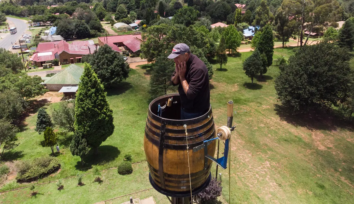Pandangan aerial Vernon Kruger berada dalam tong di atas tiang dengan ketinggian 25 meter di Dullstroom, 16 Januari 2020. Kruger ingin tinggal di dalam tong selama 64 hari untuk pecahkan rekor yang dipegang dirinya pada 1997 dengan tinggal di dalam tong selama 54 hari. (ANTOINE DEMAISON/AFP)