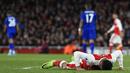 Striker Arsenal, Alexis Sanchez, terjatuh saat melawan Leicester pada laga Premier League di Stadion Emirates, London, Rabu (26/4/2017). Arsenal menang 1-0 atas Leicester. (AFP/Will Oliver)