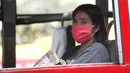 Seorang wanita mengenakan masker pelindung di sebuah bus umum di Bangkok, Thailand (14/1). Tingkat kabut asap yang sangat tinggi diperburuk oleh pola cuaca yang meningkatkan kewaspadaan di seluruh Asia. (AP Photo/Sakchai Lalit)