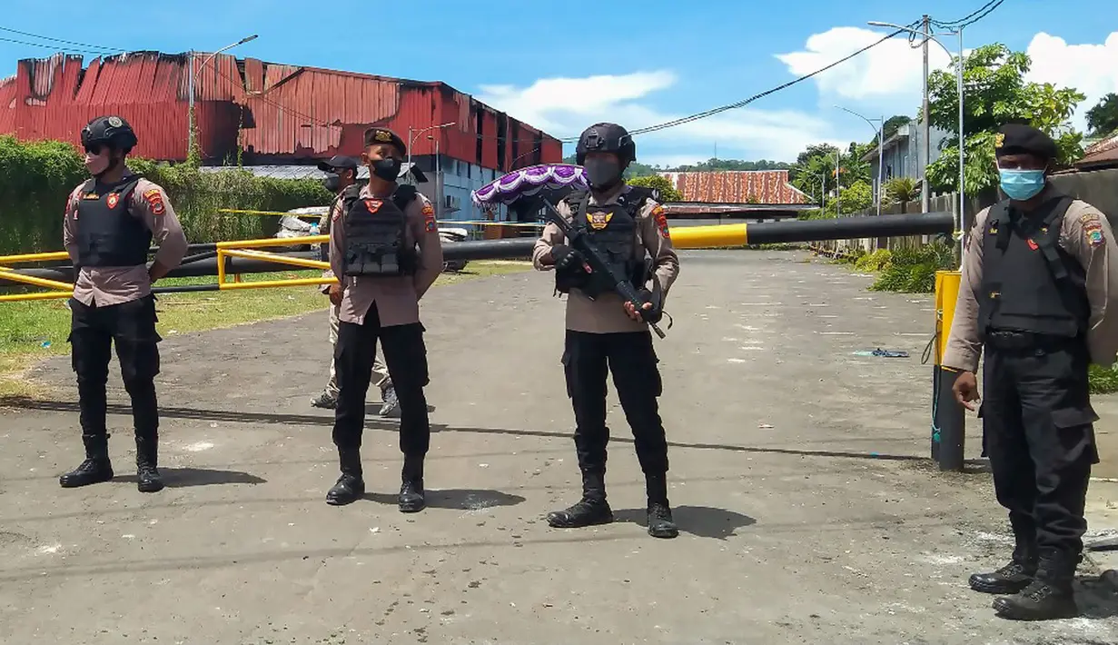 Polisi berjaga di luar klub malam Double O usai bentrok antara dua kelompok di Sorong, Papua Barat, Selasa (25/1/2022). Bentrok antara dua kelompok menewaskan 18 orang di klub malam Double O. (YANTI/AFP)