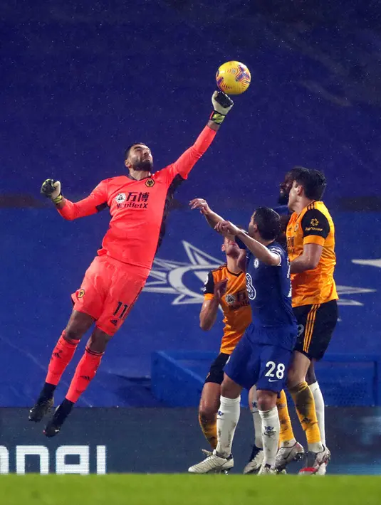 Penjaga gawang Wolverhampton Wanderers Rui Patricio (kiri) meninju bola saat melawan Chelsea pada pertandingan Liga Inggris di Stamford Bridge Stadium, London, Inggris, Rabu (27/1/2021). Pertandingan berakhir dengan skor 0-0. (AP Photo/Frank Augstein)