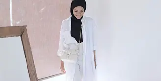 Tampil trendy ala monochrome saat di kantor dengan kemeja tunik berwarna putih yang dijadikan outer serta celana senada dan inner dan jilbab berwarna hitam. (instagram/ayudiac)