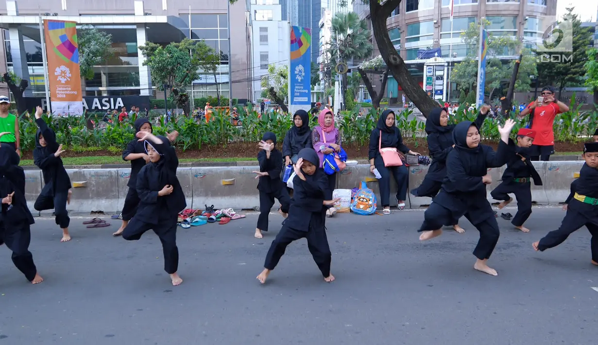 Sejumlah pendekar perempuan memperagakan jurus beladiri di hadapan warga saat Car Free Day di kawasan Senayan, Jakarta, Minggu (8/10). Aksi yang tergabung dalam Dewan Kesehatan Rakyat ini untuk memeriahkan CFD. (Liputan6.com/Fery Pradolo)