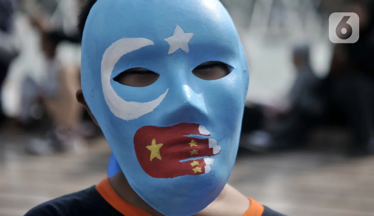Warga mengenakan topeng bendera Turkestan Timur saat menggelar Aksi Save Uighur selama CFD, Jakarta, Minggu (22/12/2019). Aksi digelar sebagai bentuk peduli terhadap muslim Uighur di Xinjiang yang diduga terus mengalami tindakan kekerasan oleh pemerintah China. (merdeka.com/Iqbal S. Nugroho)