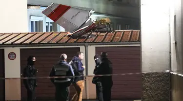 Petugas polisi berdiri di dekat ekor pesawat kecil yang melakukan pendaratan darurat di sebuah kediaman, di Villejuif, luar Paris, Senin (4/12/2023). (AP Photo/Michel Euler)