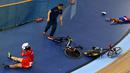 Seorang staff membantu dua pebalap yang bertabrakan yaitu Luo Xiao Ling , dari China (kiri) dan Marlies Mejias Garcia dari Kuba pada Kejuaraan UCI World Track Cycling Championships di London, Sabtu (5/3/2016). (REUTERS/Andrew Winning)   