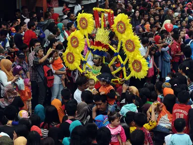 Peserta parade Pesta Rakyat Bogor melintas di tengah-tengah lautan massa yang memenuhi ruas Jalan Surya Kencana, Bogor, Senin (22/2/2016). Pesta Rakyat Bogor 2016 bersamaan dengan perayaan  Cap Go Meh di Kota Bogor. (Liputan6.com/Helmi Fithriansyah)