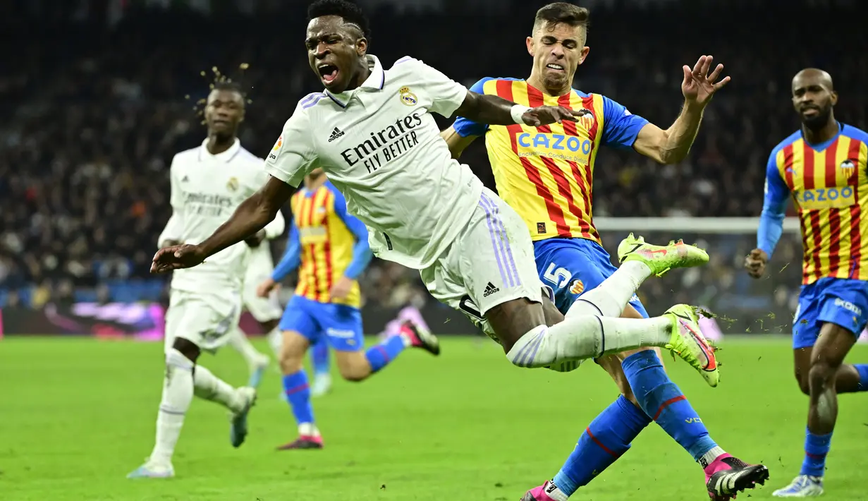 Pemain Valencia, Gabriel Paulista, menjatuhkan penyerang Real Madrid, Vinicius jr pada laga Liga Spanyol di Stadion Santiago Bernabeu, (2/2/2023). Gabriel Paulista dikartu merah wasit karena mengganjal Vinicius. Pelanggaran ini sempat memicu keributan antara kedua tim. (AFP/Javier Soriano)