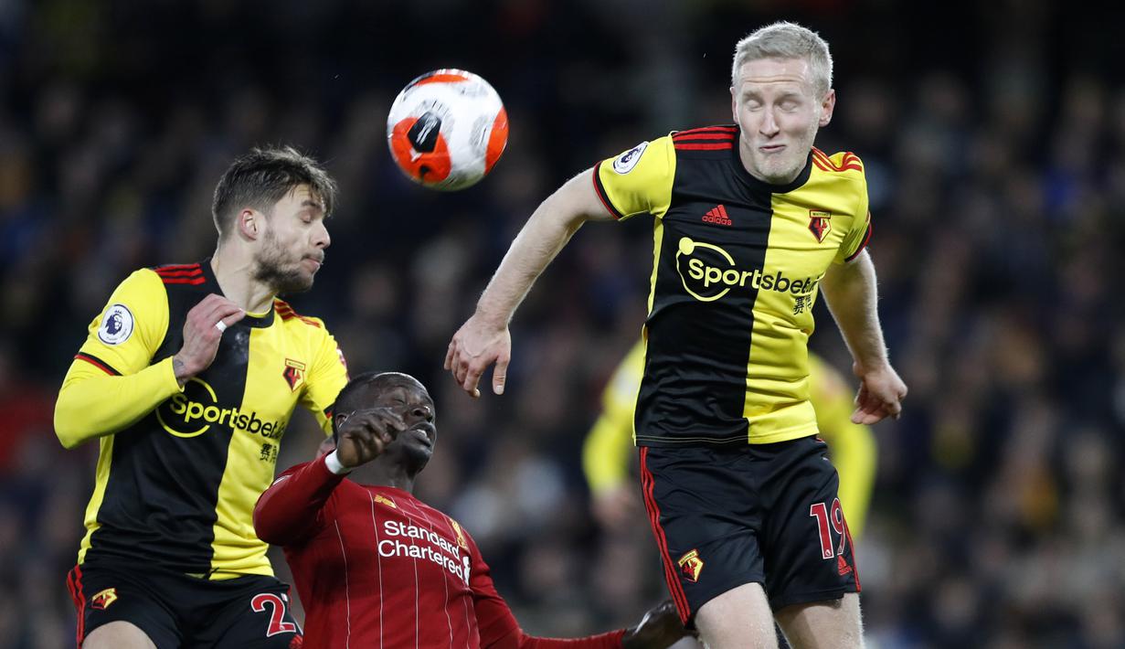 Pemain Watford, Kiko Femenia, duel udara dengan penyerang Liverpool, Sadio Mane pada laga Premier League di Stadion Vicarage Road, Sabtu (29/2/2020). Watford menang 3-0 atas Liverpool. (AP/Alastair Grant)