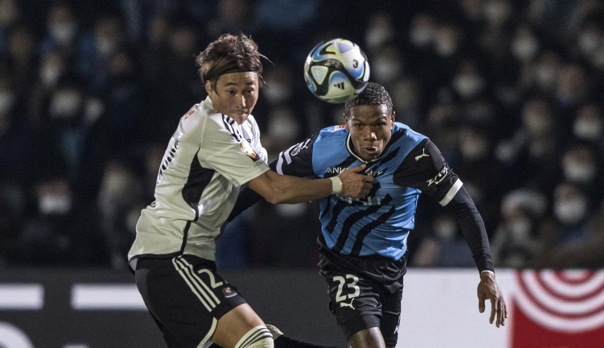 Pemain Kawasaki Frontale, Marcinho (kanan), berebut bola dengan pemain Yokohama F. Marino, Katsuya Nagato, dalam pertandingan J-League dalam pertandingan yang berlangsung di Todoroki Stadium, Kawasaki, Jumat (17/2/2023). (AFP/Yuichi Yamazaki)