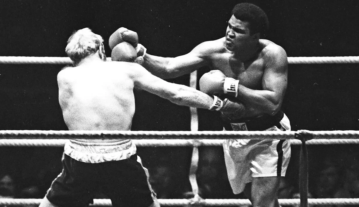 Muhammad Ali saat menghantam Richard Dunn dengan pukulan keras dalam turnamen WBC & WBA kelas berat di Munich, Jerman, (24/5/1976). Ali wafat pada usia 74 tahun dan dimakamkan di kota kelahirannya di Louisville, Kentucky. (REUTERS/Action Images/MSI)