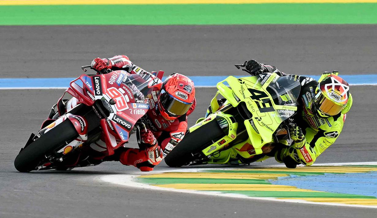 Pembalap Ducati Lenovo Team asal Spanyol, Marc Marquez (kiri) beradu kecepatan dengan Fabio Di Giannantonio (Pertamina Enduro VR46 Racing Team) saat Sprint Race MotoGP Brasil 2026 di Autodromo Internacional Ayrton Senna, Goiania, Sabtu 21 Maret 2026 waktu setempat atau Minggu (22/3/2026) dini hari WIB. Pembalap Ducati Lenovo Team, Marc Marquez sukses merebut kemenangan dalam Sprint Race MotoGP Brasil 2026. (EVARISTO SA/AFP)