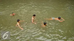 Sejumlah anak berenang di Anak Sungai Ciliwung di Jalan Labu, Kelurahan Mangga Besar sudah mulai membaik, Jakarta, Selasa (17/5). Kondisi air yang mulai jernih dimanfaatkan mereka untuk bermain dan berenang. (Liputan6.com/Gempur M Surya)