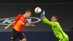 Pemain FC Shakhtar Donetsk, Valeriy Bondar, berebut bola dengan kiper FC Basel, Dorde Nikolic, pada perempat final di Veltins Arena, Selasa (11/8/2020). Shakhtar Donetsk menang dengan skor 4-1. (Wolgang Rattay/Pool Photo via AP)