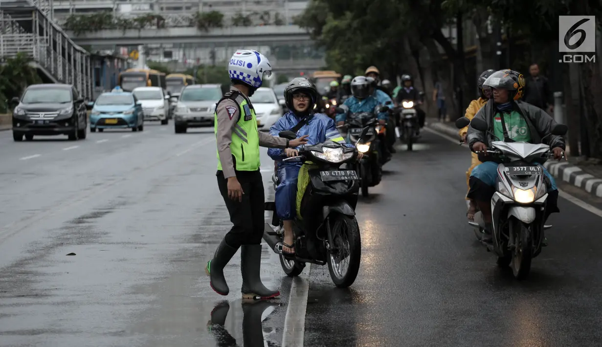 Polisi melakukan tindakan tilang kepada pengendara motor yang melanggar aturan jalur khusus sepeda motor di Jalan MH Thamrin, Jakarta, Kamis (8/2). Pengendara yang melanggar, ditilang dengan denda maksimal Rp 500 ribu. (Liputan6.com/Arya Manggala)