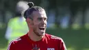 Pemain Timnas Wales, Gareth Bale, tertawa saat mengikuti latihan jelang laga UEFA Nations League di Hensol, South Wales, Senin (31/8/2020). Wales akan berhadapan dengan Finlandia. (AFP/Geoff Caddick)