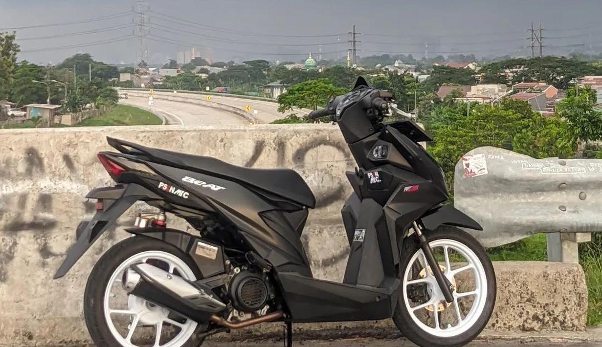 BeAT berkelir hitam doff ini dipadukan dengan velg putih. Penggunaan warna cerah pada velgnya berhasil mendongkrak penampilan motor ini menjadi lebih sporty. (Source: Instagram/@ygdiambukandiri)