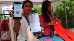 Pengunjung memperlihatkan aplikasi QR Store saat Dimo Pop Up Market di Jakarta, Selasa (26/4). sistem Pay by QR ini diintegrasikan pada layanan mobile banking bank maupun aplikasi uang elektronik. (Liputan6.com/Angga Yuniar)