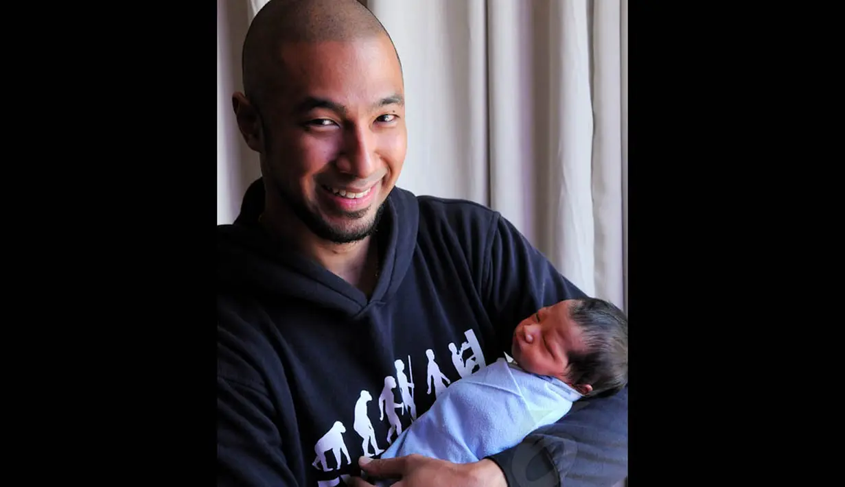 Penyanyi Marcell Siahaan terlihat bahagai saat menggendong anak ketiganya, Jakarta, (24/9/14). (Liputan6.com/Faisal R Syam)
