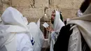 Sejumlah orang yang mengenakan penutup kepala dari kasta imam Yahudi berdoa menjelang Paskah di depan Tembok Barat, Yerusalem (13/4). Mereka melakukan upacara sebanyak tiga kali dalam setahun, yaitu Paskah, Shavuot dan Sukkot.  (AP Photo / Ariel Schalit) 