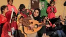 Ruaa Hassouna memainkan alat musik Oud untuk anak-anak Palestina mereka di Rafah, Selatan Jalur Gaza, 18 Desember 2023. (SAID KHATIB/AFP)