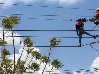 Petugas PLN memperbaiki jaringan listrik di Palu, Sulawesi Tengah, Sabtu (6/10). PT Perusahaan Listrik Negara (PLN) memastikan kondisi listrik di Kota Palu semakin membaik pasca gempa dan tsunami. (Liputan6.com/Fery Pradolo)