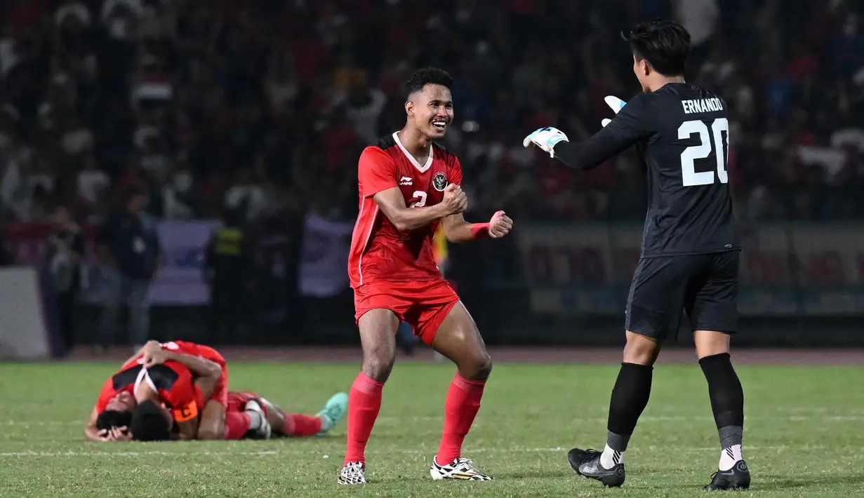 Amiruddin Bagas Kaffa Arrizqi (tengah) dari Indonesia melakukan selebrasi dengan kiper Ernando Ari Sutaryadi (kanan) setelah mengalahkan Thailand pada pertandingan final sepak bola putra di SEA Games ke-32 di Phnom Penh pada 16 Mei 2023. (MOHD RASFAN/AFP)