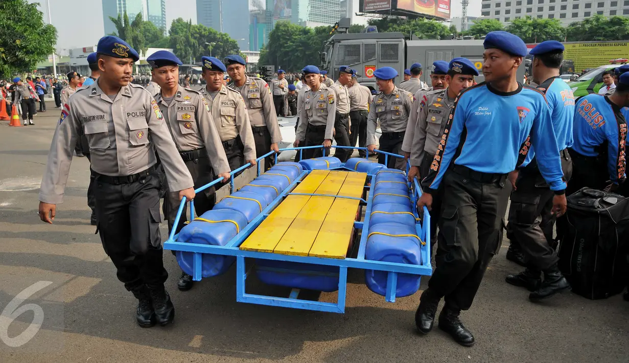 Petugas mempersiapkan perahu karet ketika apel siaga banjir di lapangan Direktorat Lalu Lintas Polda Metro Jaya, Jakarta, Jumat (27/11). Apel siaga banjir ini dipimpin Kapolda Metro Jaya Irjen Pol M Tito Karnavian. (Liputan6.com/Gempur M Surya)