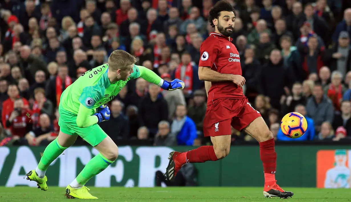 Penyerang Liverpool, Mohamed Salah menggiring bola melewati kiper Everton, Jordan Pickford selama pertandingan Liga Inggris di Anfield Stadium (2/12). Liverpool menang tipis 1-0 atas Everton. (AP Photo / Jon Super)