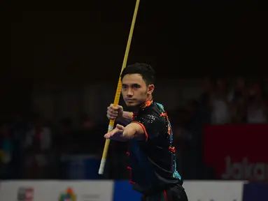 Atlet Wushu Indonesia Hulaefi Achmad beraksi pada laga final Men's Daoshu dan Gunshu Asian Games 2018 di JIexpo,Hall B, Kemayoran, Jakarta, Selasa (21/8). Achmad berhasil meraih perunggu dan sukses merebut total 19,41 poin. (Merdeka.com/Imam Buhori)