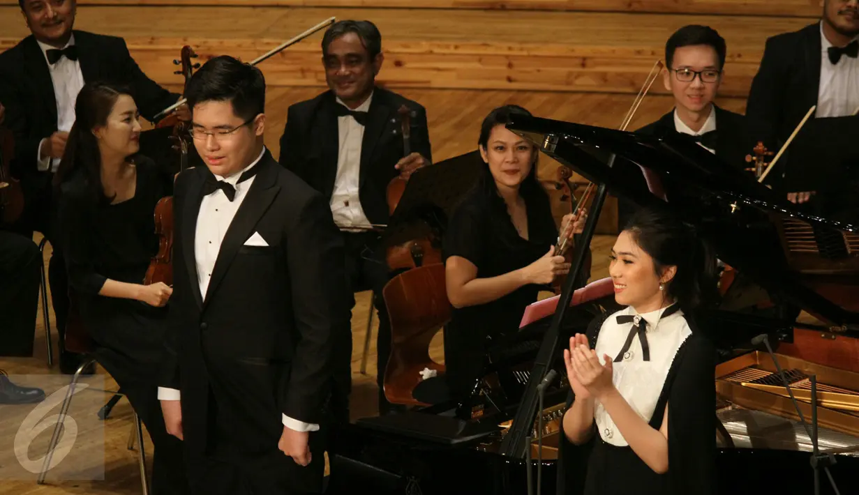 Isyana Sarasvati dan Jonathan Kuo memberi salam kepada penonton usai tampil dalam konser musik klasik di Aula Simfonia Jakarta, Sabtu (6/5). Usai tampil, Jonathan Kuo mengaku sangat puas dengan konser tersebut. (Liputan6.com/Fery Pradolo)