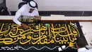 Seorang pekerja menyulam kaligrafi Islam menggunakan benang perak murni atau benang perak berlapis emas pada tahap akhir pembuatan Kiswah Kabah di Mekah, Arab Saudi, 6 Juli 2022. Jemaah haji berkumpul di Kota Suci Mekah untuk haji terbesar sejak pandemi virus corona COVID-19. (AP Photo/Amr Nabil)